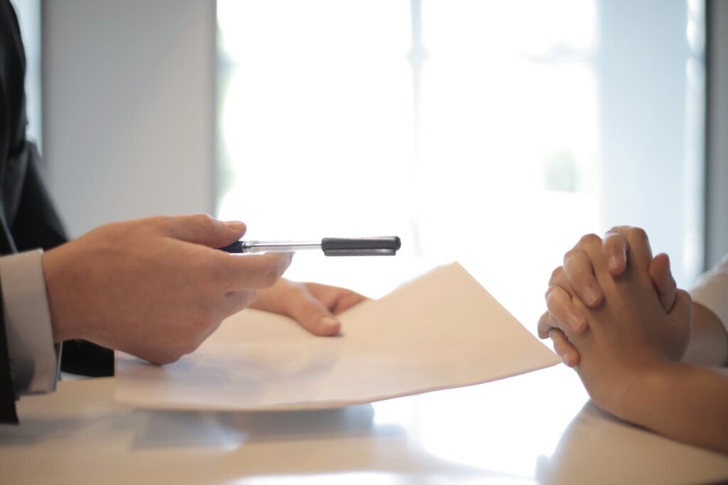 Duas pessoas assinando um Contrato de compra e venda